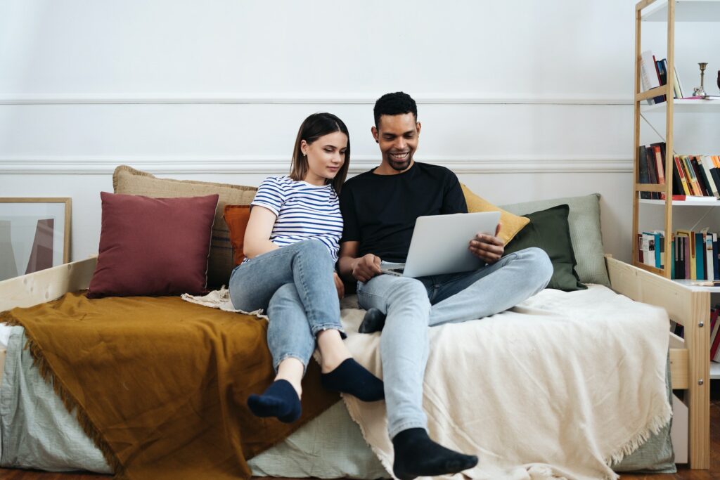 Lovely mixed race couple using laptop on couch